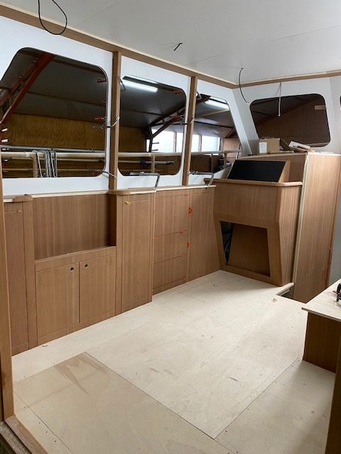 Stuurhut in aanbouw met eiken console en kasten bij de grote ramen