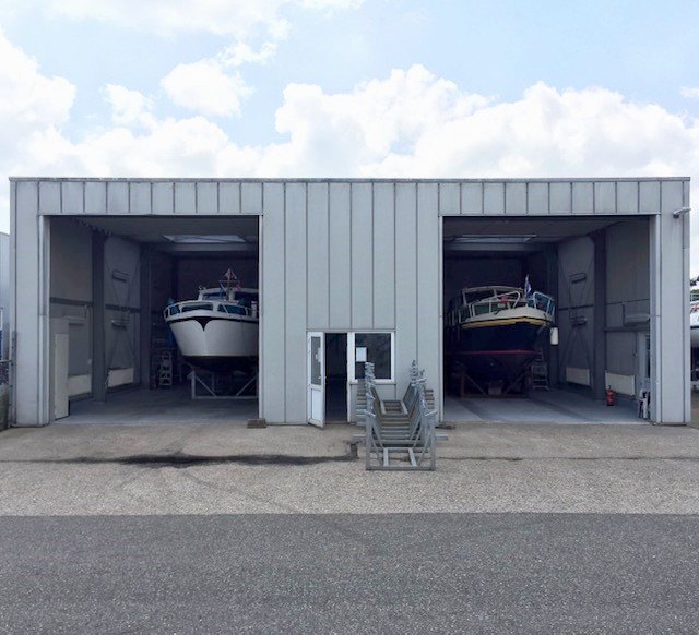 De twee doe-het-zelfloodsen met in elke loods een motorboot